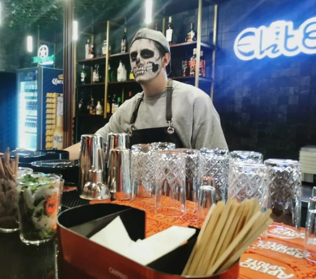 Bartender de Élite Paseo Gastronómico con maquillaje de calavera en la barra